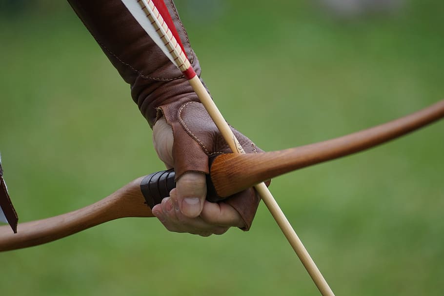 person's left hand holding bow with arrow, arch, archery, objectives