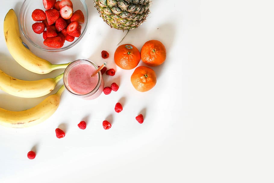 photo of three orange fruits, strawberries on clear glass bowl beside three bananas HD wallpaper