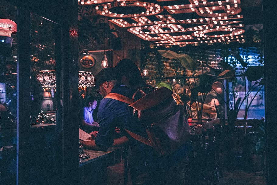 man leaning on table inside building, male, bar, backpack, bag HD wallpaper