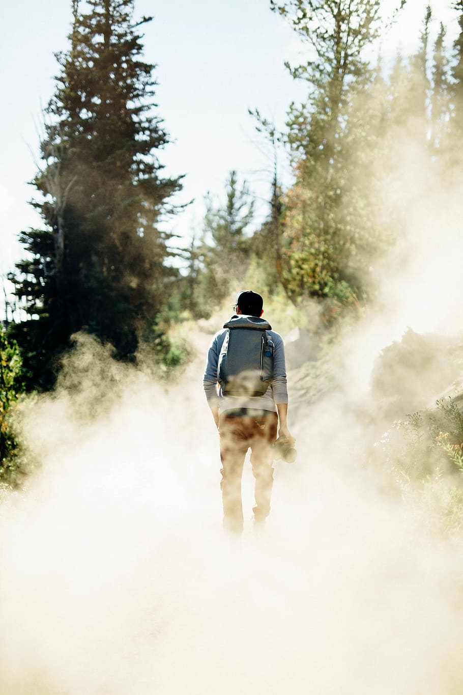 man standing with smokes, man walking smoke pathway during daytime HD wallpaper