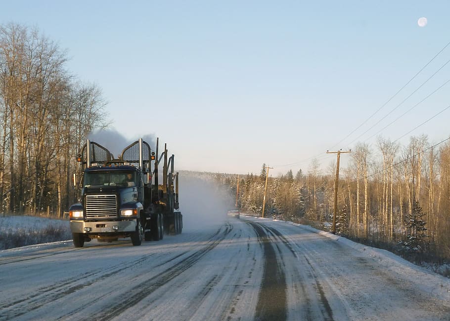 black semi-truck on snow road, logistics, logging, transportation