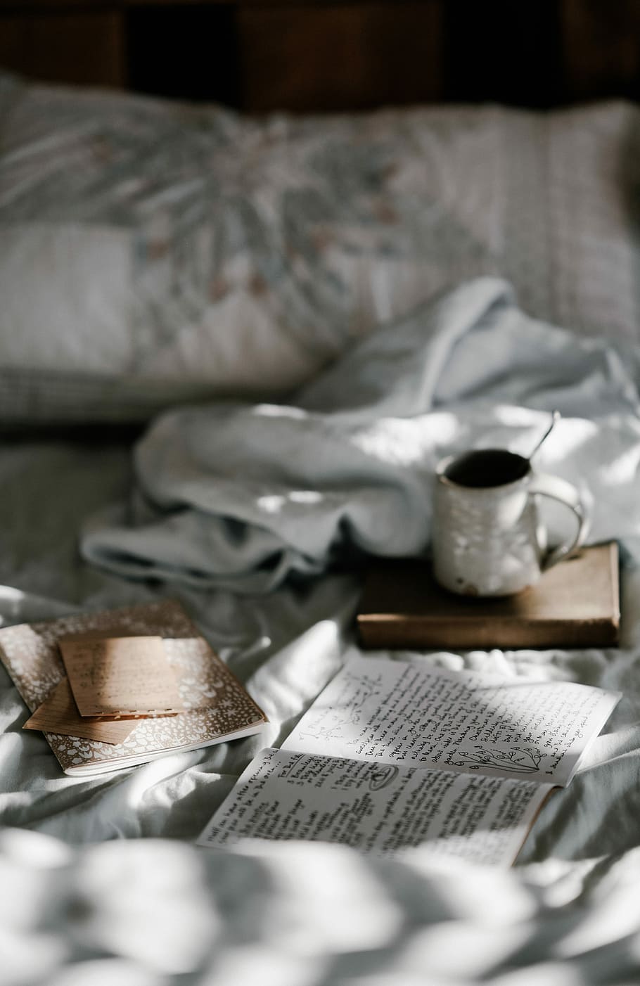 coffee mug on a brown wooden coaster near white blanket, white ceramic mug on brown book HD wallpaper