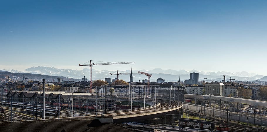 aerial photography of empty road overlooking cranes under blue sky at daytime HD wallpaper