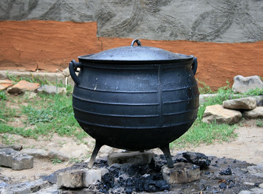 black cooking pot on three gray pavements at daytime, black pot