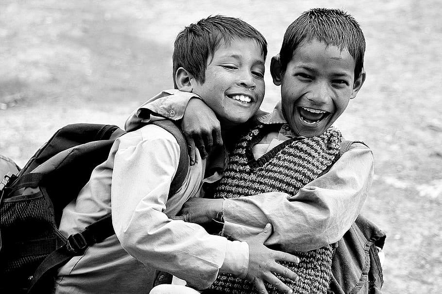 grayscale photography of two boys hugging while laughing, grayscale photography of children hugging each other