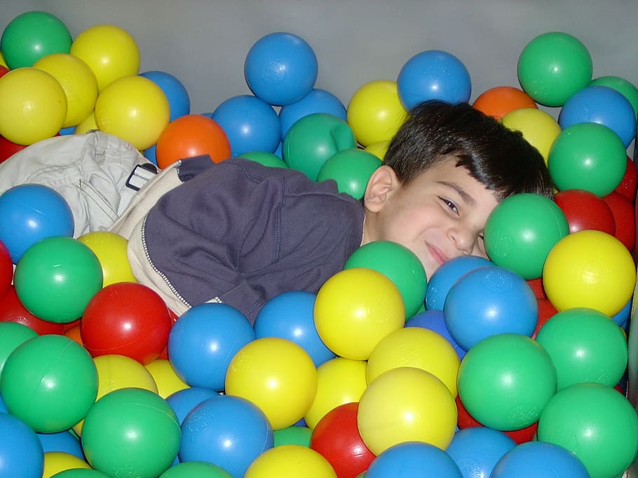 boy laying on play balls, plastic, child, pool, kid, smile HD wallpaper