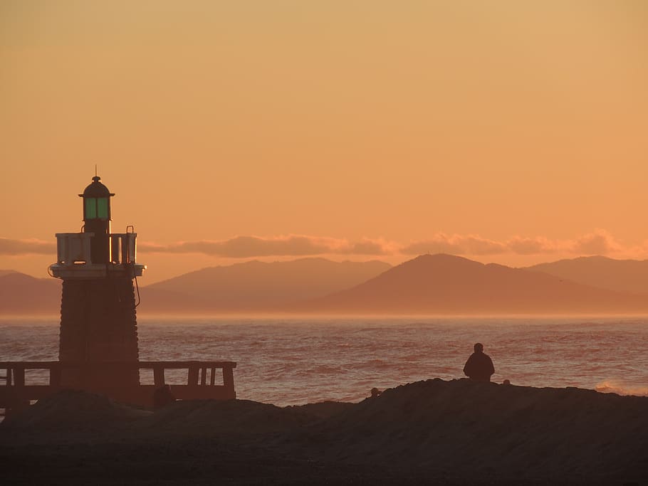 lighthouse, sunset, ocean, side, twilight, sky, sea, water HD wallpaper