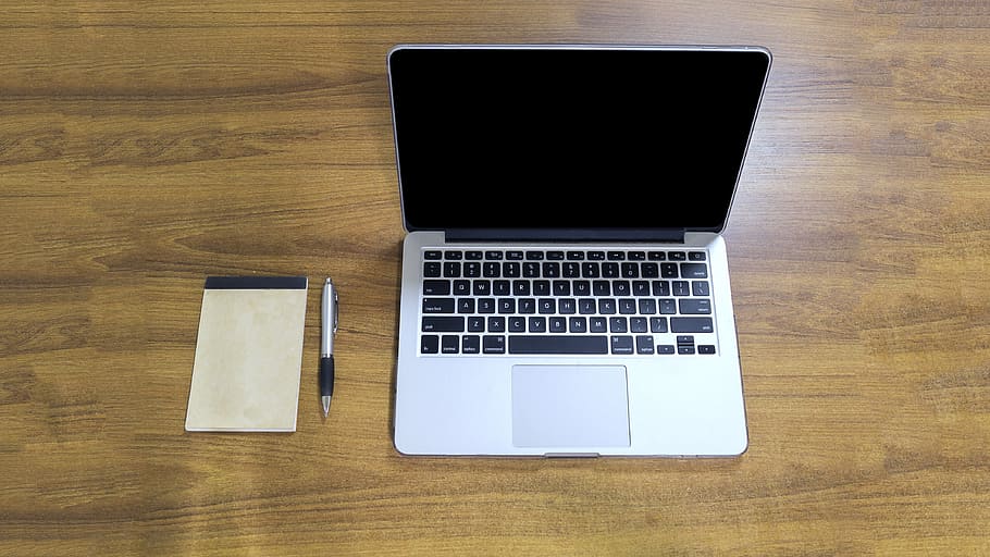 MacBook Pro, white pad, and silver click pen on top of brown wooden table, HD wallpaper