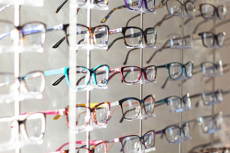arranged assorted-color eyeglasses on rack, assorted-color framed eyeglasses