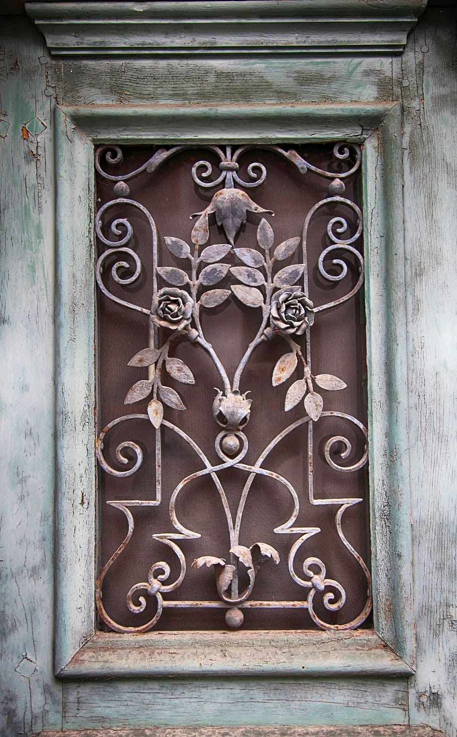 closeup photo of brown and gray floral grille, window, door window