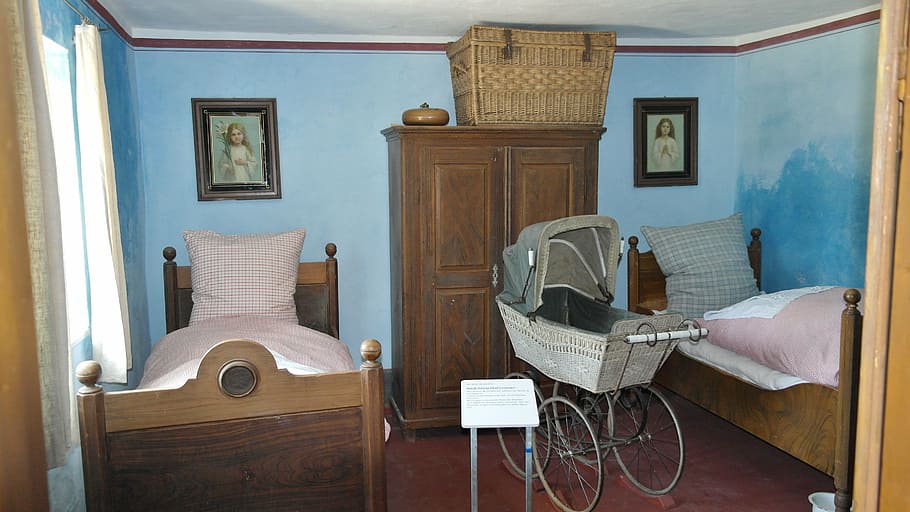 baby's gray pram stroller in between two bed frames, bedroom