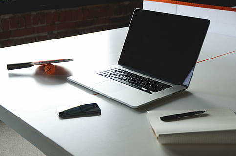 turned-off black and gray laptop computer beside pen and notebook on table HD wallpaper