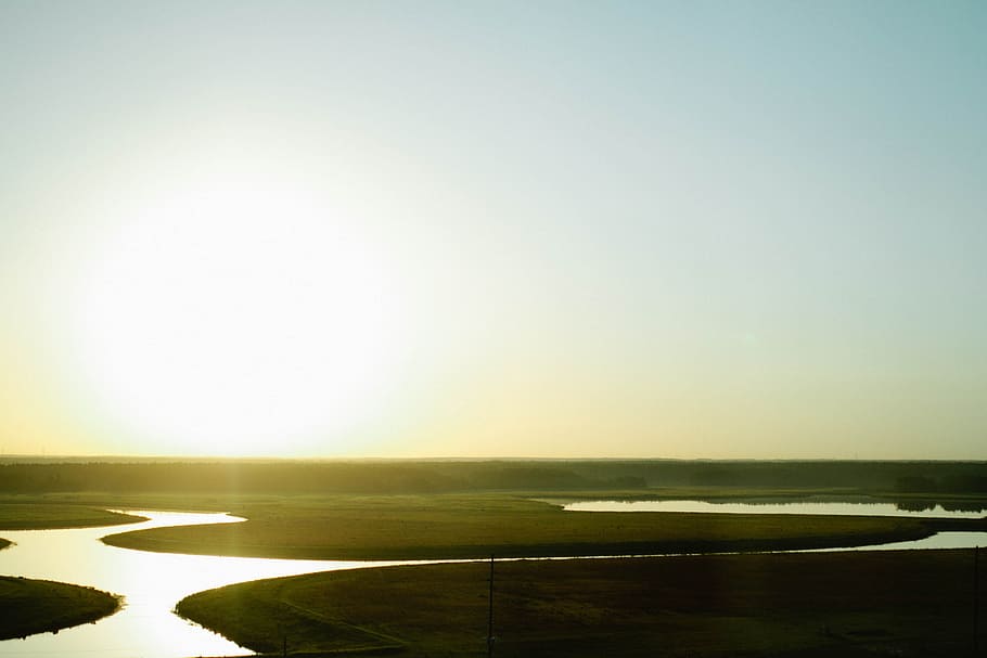 aerial photography of green grass field near body of water at daytime HD wallpaper