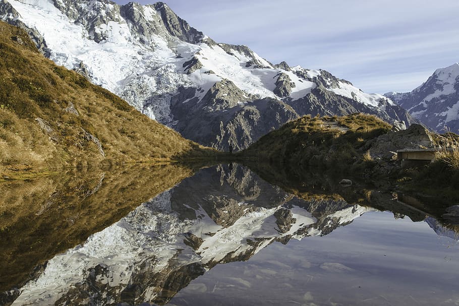 landscape photography of mountain covered with snow, mirror photography of hills coated with snow during daytime HD wallpaper