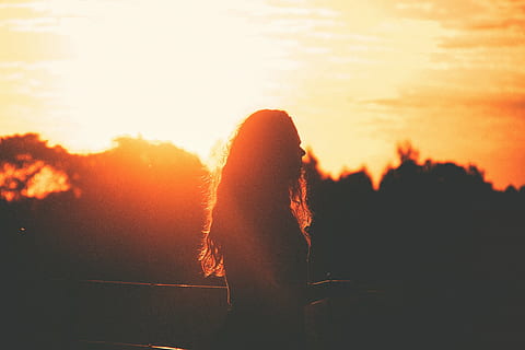 silhouette of woman standing and facing right, sunset, sun rays HD wallpaper
