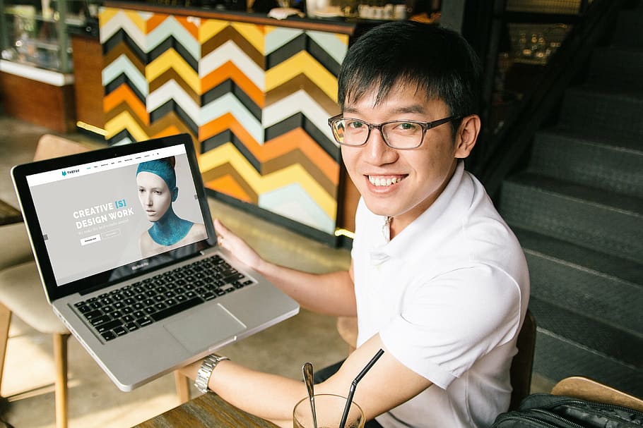 man wearing white polo shirt holding MacBook Pro, laptop, mockup HD wallpaper