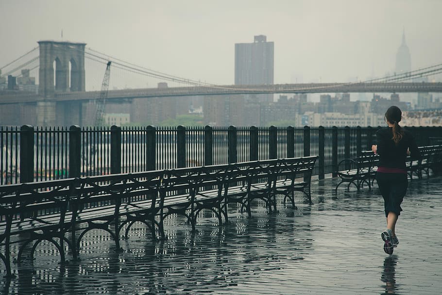woman running near the body of water with Brooklyn Bridge in the background, woman in black shirt running near bench HD wallpaper