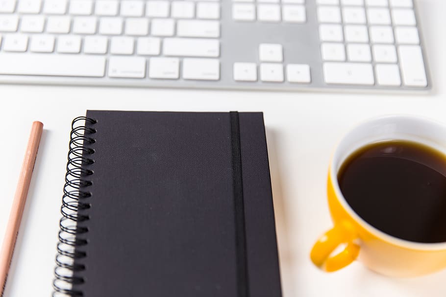 Computer keyboard, coffee cup, notebook and pencil on a white desk HD wallpaper