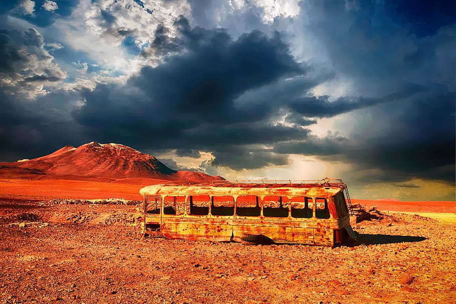 photography of brown bus frame next to brown mountain during daytime HD wallpaper