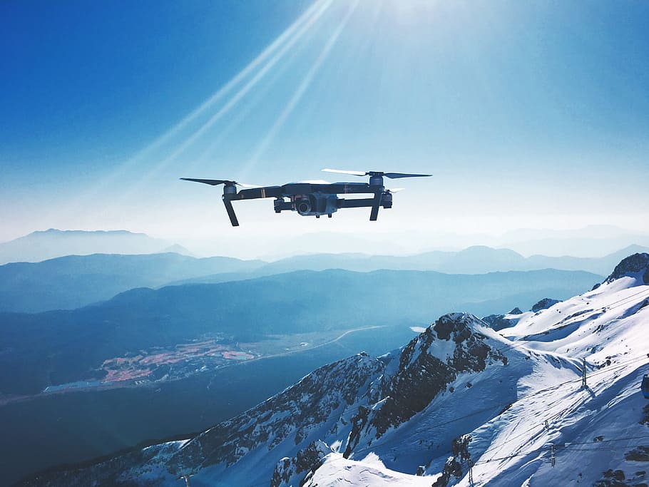white quadcopter drone flying near snow mountain during daytime, gray quadcopter drone in flight HD wallpaper