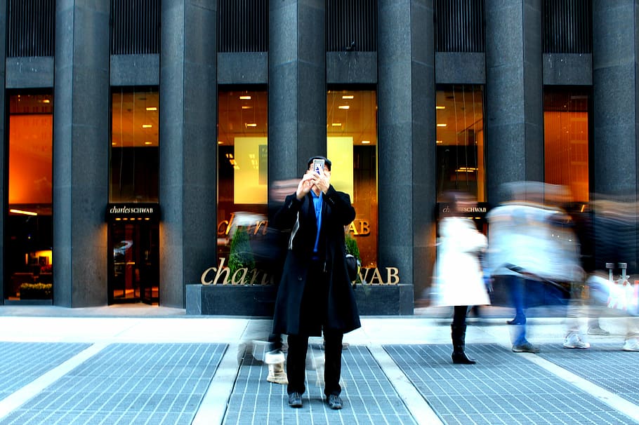 time-lapse photography on man holding phone, man standing front of building while holding smartphone HD wallpaper