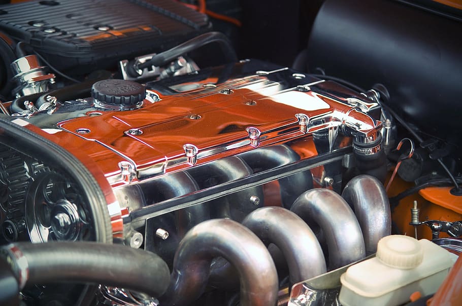 close up photography of orange and gray vehicle engine, motor