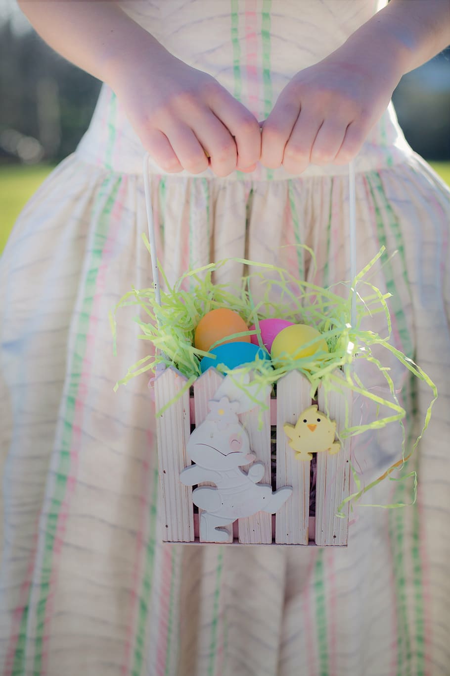 girl in pink and green stripe dress holding basket of easter eggs HD wallpaper