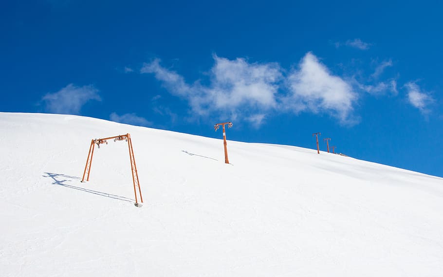 snow mountain with orange pole, photo of brown stick in snow under blue calm sky HD wallpaper