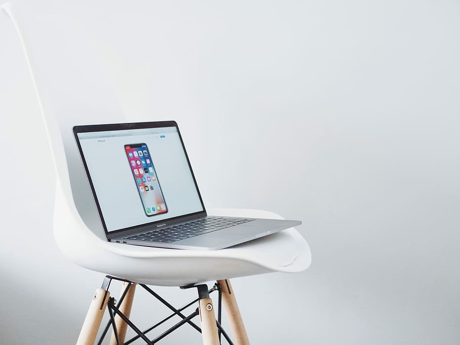 turned on MacBook on top of white chair, turned-on MacBook Air with space gray iPhone X display on chair HD wallpaper