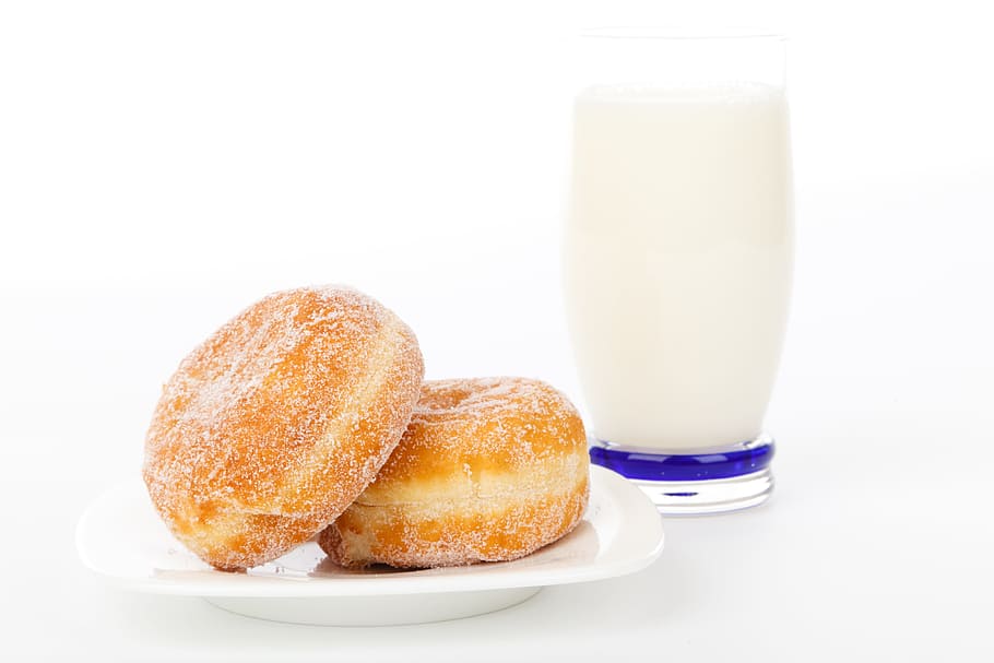 milk in clear drinking glass beside two doughnuts, breakfast HD wallpaper