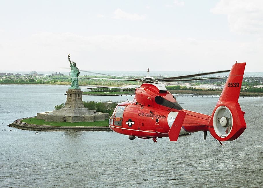 red helicopter flying towards Statue of Liberty, Liberty, New York