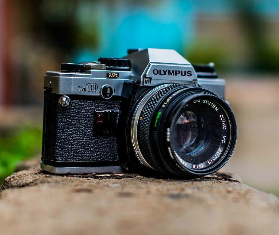 macro shot of black Olympus camera, selective focus photography of black and gray Olympus digital camera on brown surface at daytime HD wallpaper