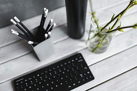 Black keyboard with pencils on a white table, bottle, plant, wood - Material HD wallpaper