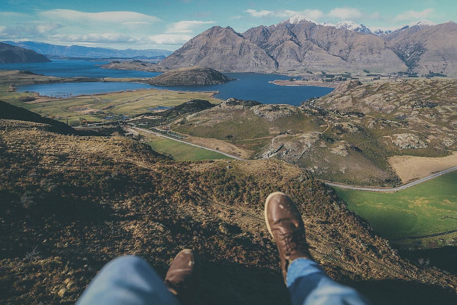 person sitting on cliff during daytime, person sitting near cliff overlooking mountains during daytime HD wallpaper