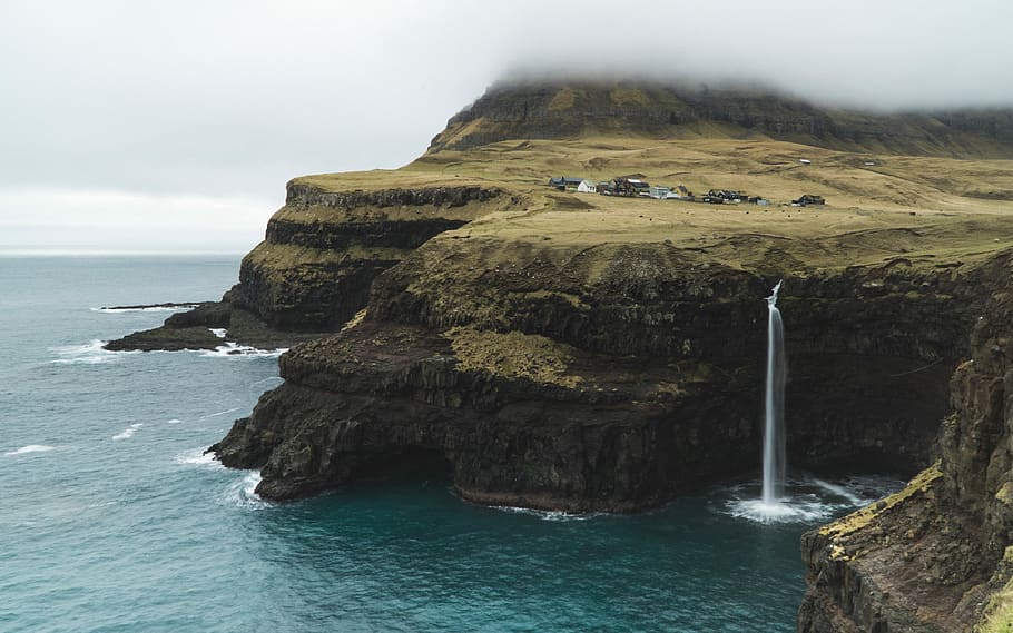 bird's-eye view photograph of cliff near body of water, landscape photo of brown cliff and body of water HD wallpaper
