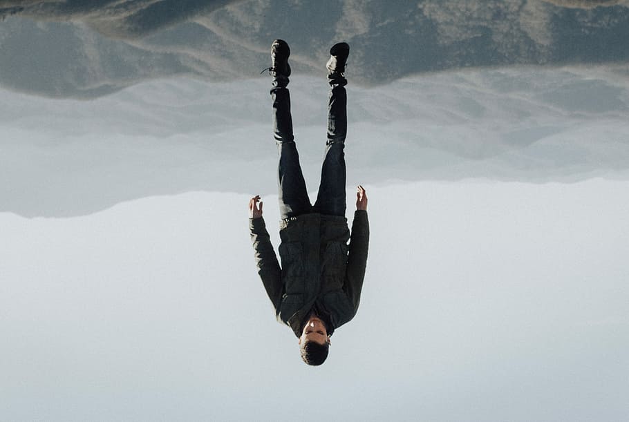 man floating above mountain, man on black mountains, person, upside down HD wallpaper