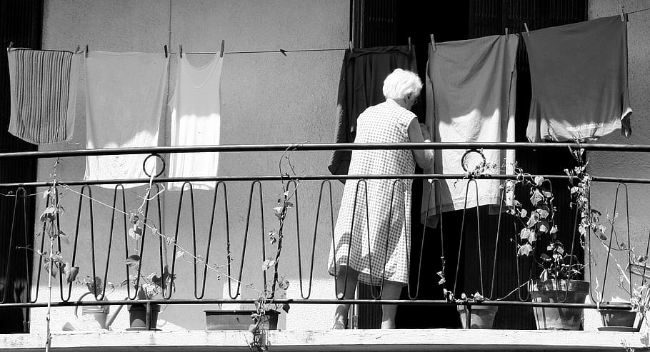 woman standing on terrace beside pot, old woman, laundry, housework