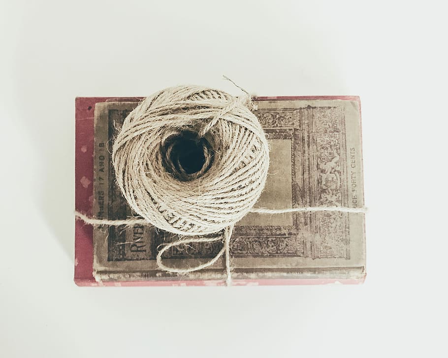 top view photo of brown yarn, beige tie on top of brown and red book HD wallpaper