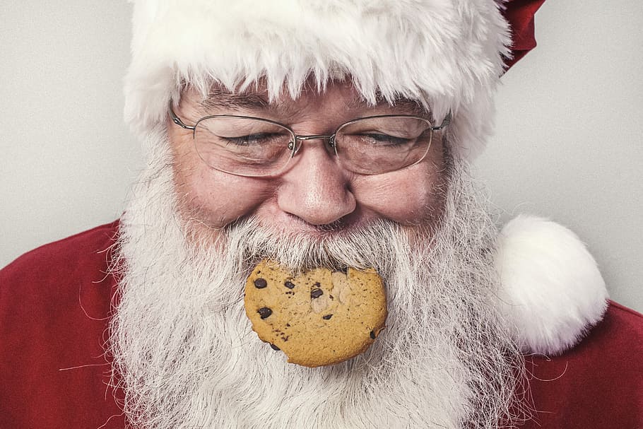 Santa Claus with cookie on his mouth, people, whimsical, lazy