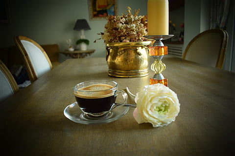 coffee in glass cup beside white rose and candle holder on dining table HD wallpaper