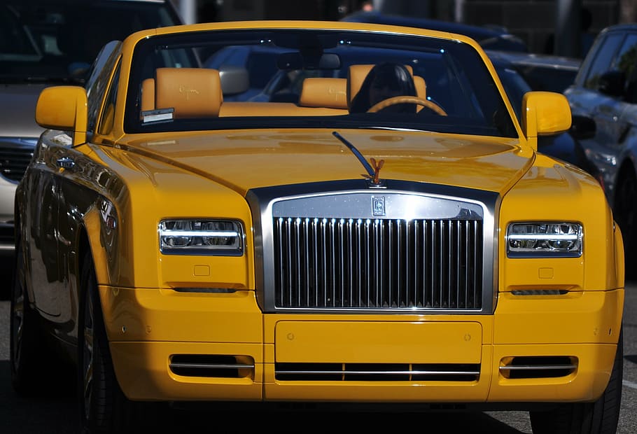 closeup photo of yellow Rolls Royce Phantom convertible sedan