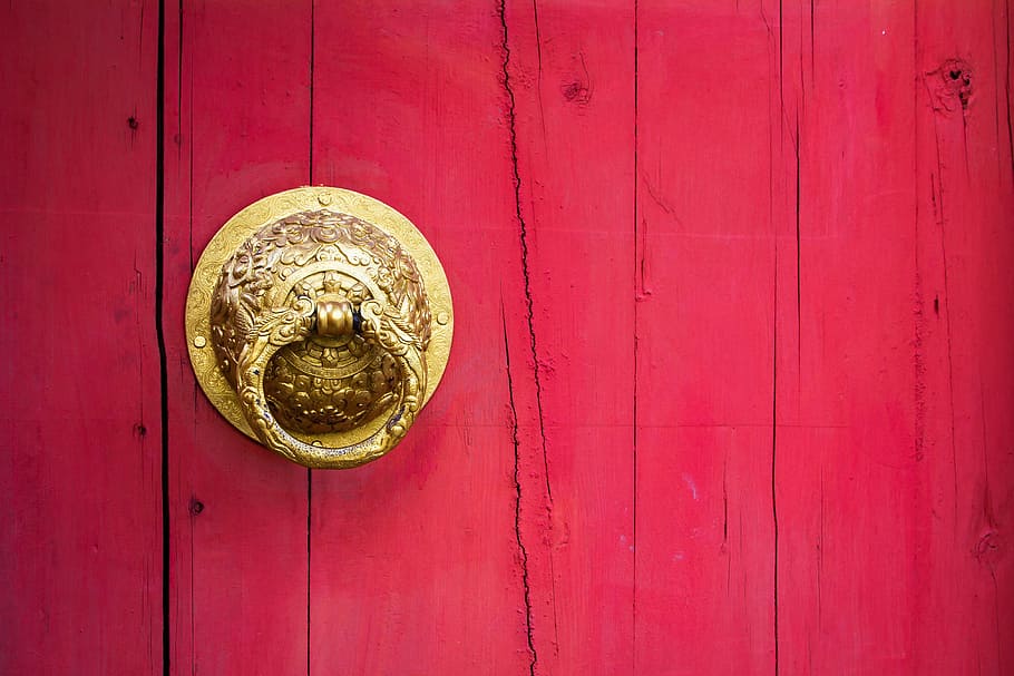 red wooden door with scrolled gold door knocker, handle, chinese