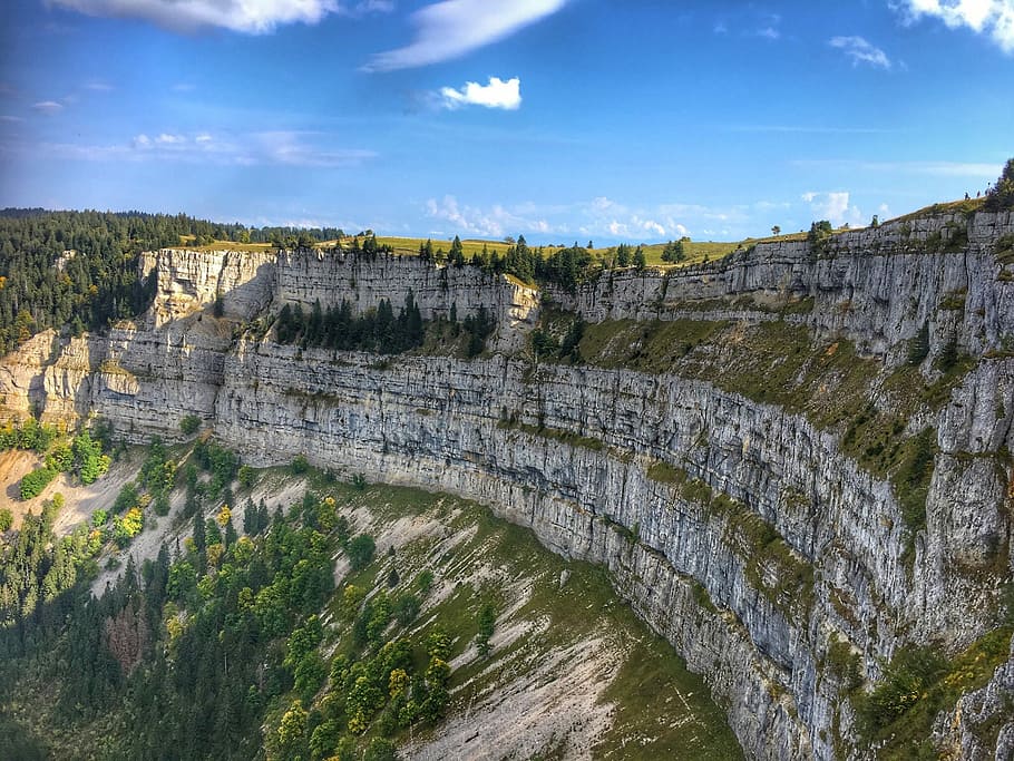 Creux du Van, trees near rock cliff, mountain, blue, sky, architecture HD wallpaper