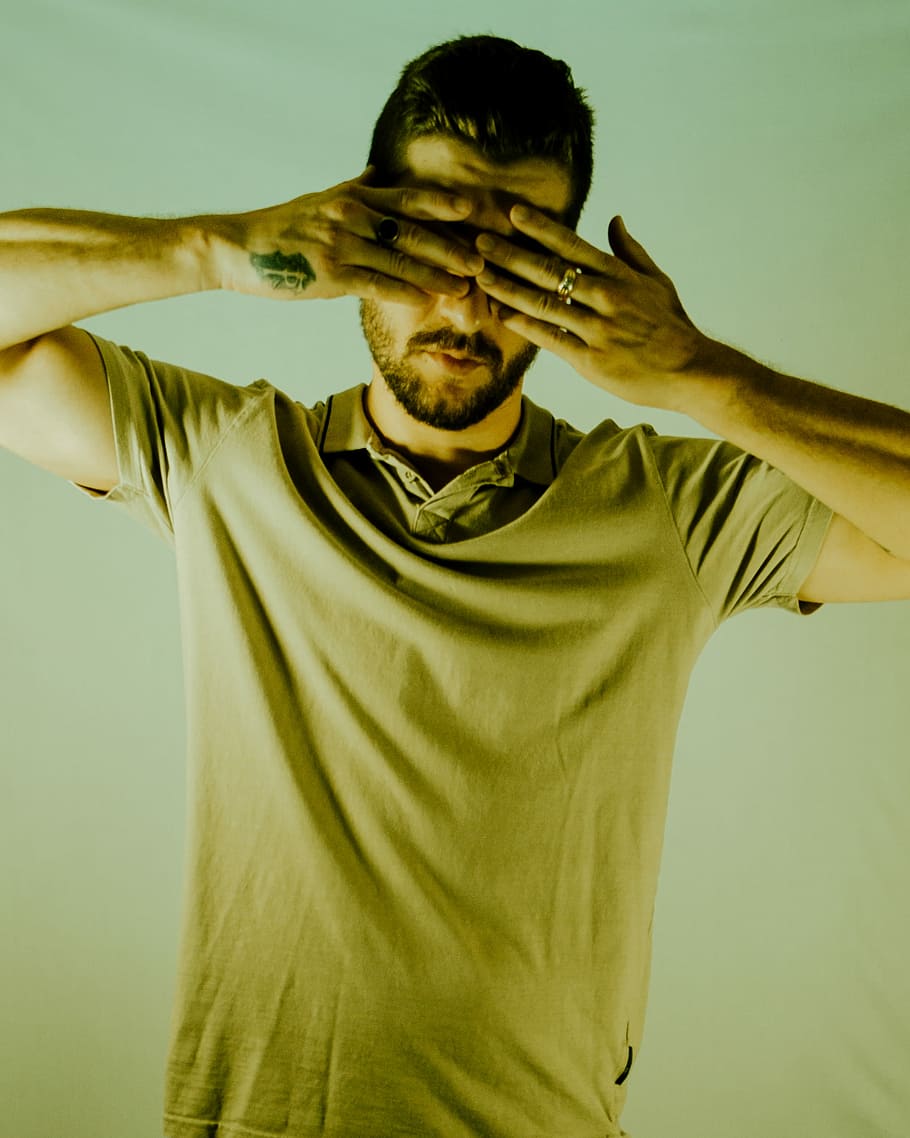 man covering his eyes using both hands, man covering his face with both hands