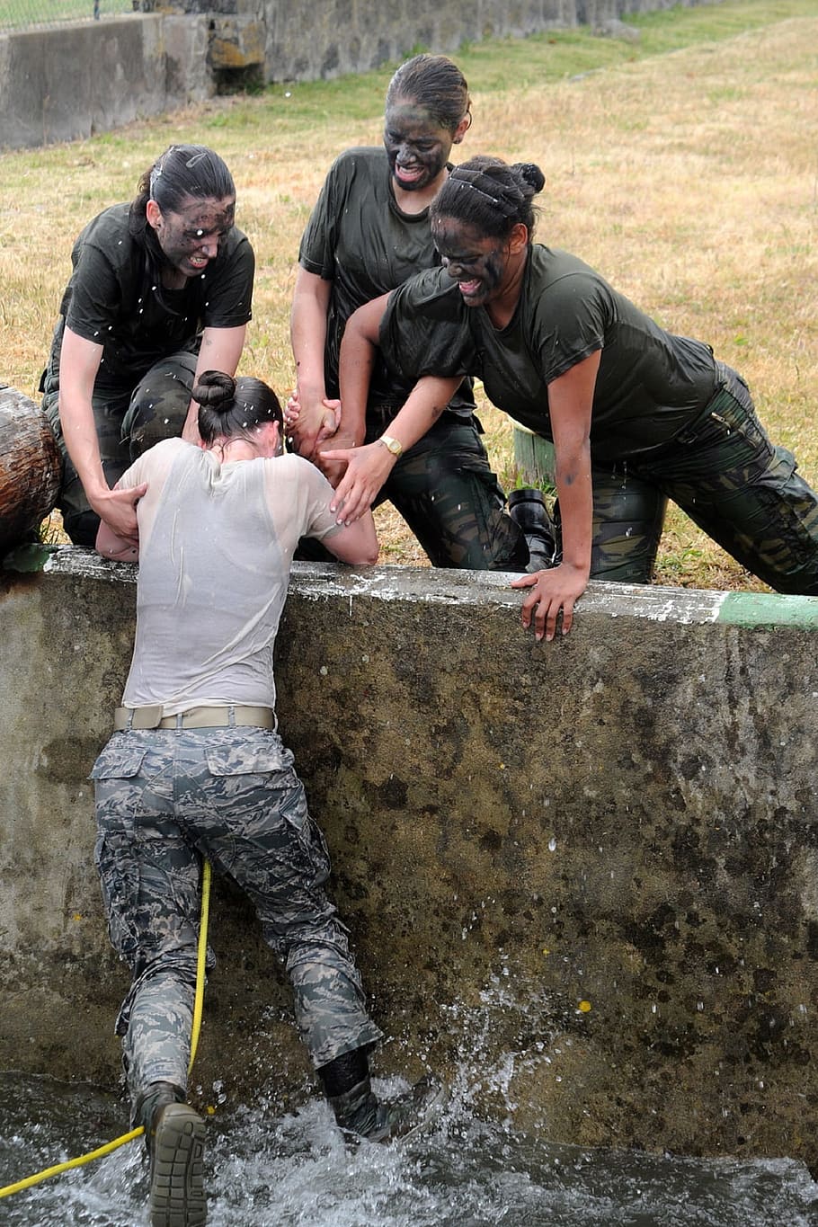 woman in type-B army uniform being pulled-up over water by three women HD wallpaper