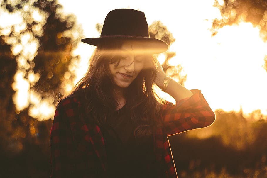 woman wearing red and black checked top and black hat, woman wearing red and black checkered dress shirt and black hat during sunrise HD wallpaper
