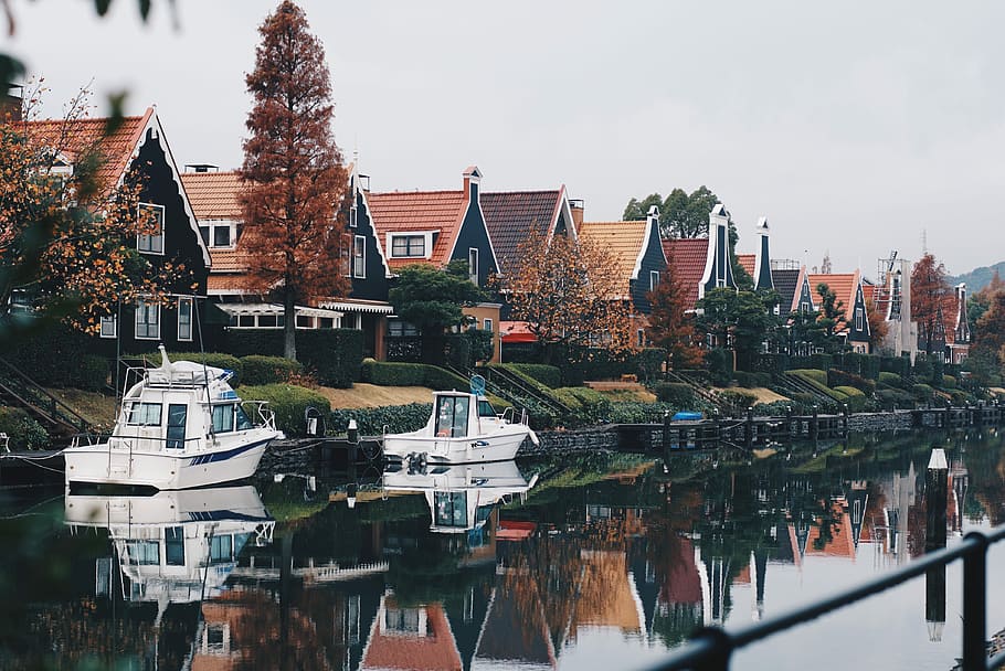 two white boats on river near brown houses at daytime, two white boats on body of water near houses HD wallpaper