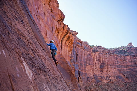 man climbing on mountain rock, person climbing on mountain during daytime HD wallpaper