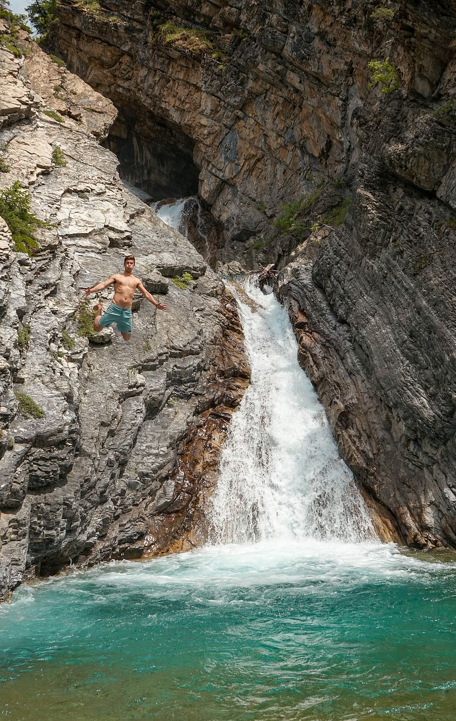 man jumping at body of water, man wearing blue shorts jumped on waterfalls HD wallpaper