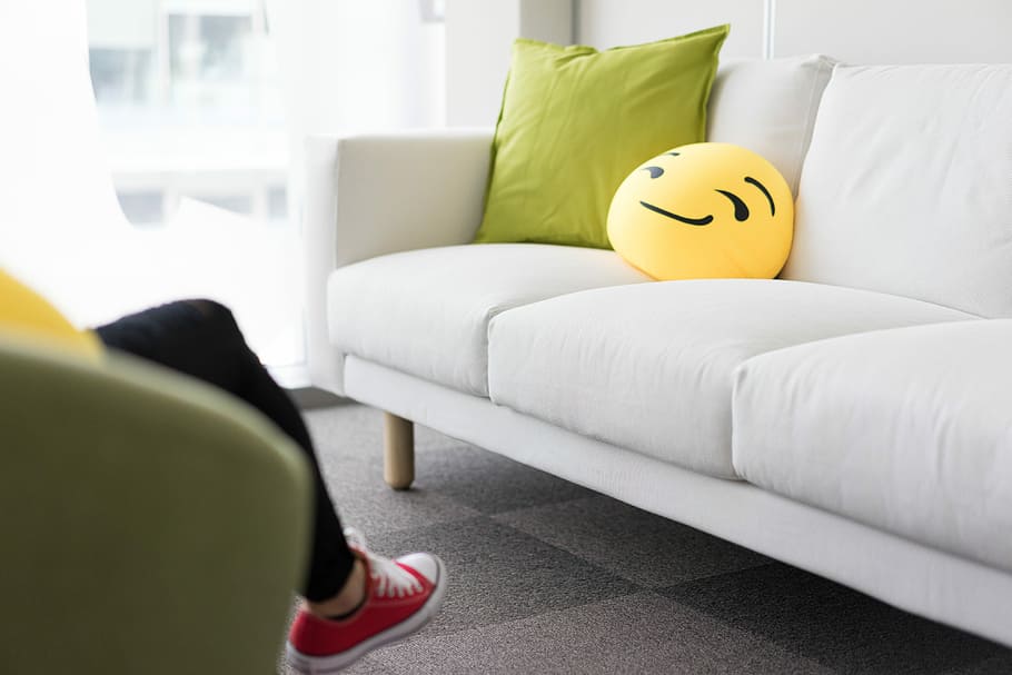 Colorful and Funny Pillows on Sofa in Modern Startup Office, green